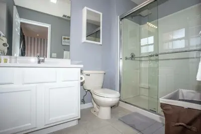 a bathroom with a toilet and a glass shower at Amazing 3 Bdrms At Encantada- 6 miles from Disney in Kissimmee