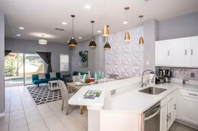 a kitchen and living room with a couch and a table at Amazing 3 Bdrms At Encantada- 6 miles from Disney in Kissimmee