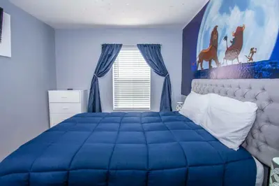 a blue bedroom with a large bed with blue walls at Amazing 3 Bdrms At Encantada- 6 miles from Disney in Kissimmee