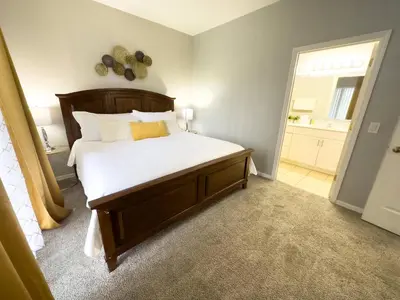 a bedroom with a large bed with white sheets at Comfortable Apart 4Bdrm3Bath- 4 miles to Disney in Orlando
