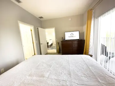 a bedroom with a white bed and a window at Comfortable Apart 4Bdrm3Bath- 4 miles to Disney in Orlando