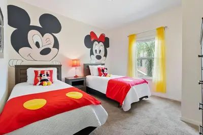 a bedroom with two beds with mickeys on the wall at Amazing 3 bedrooms At Lucaya- 7 miles from Disney in Kissimmee