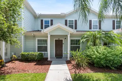 a white house with a brown door at Amazing 3 bedrooms At Lucaya- 7 miles from Disney in Kissimmee