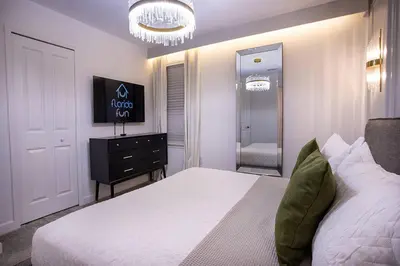 a bedroom with a bed and a dresser and a mirror at New Home 8 Bedrooms and 5 Bathrooms At Storey Lake in Kissimmee
