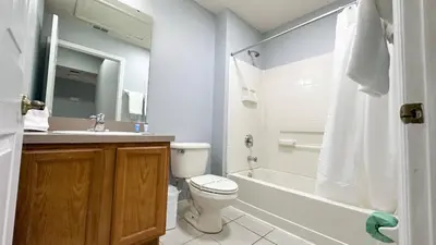 a bathroom with a toilet and a tub and a sink at Amazing 3 Bdrm At Encantada- 6 miles from Disney in Kissimmee