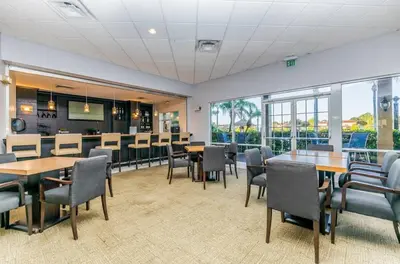 a dining room with tables and chairs and windows at Amazing 3 Bdrm At Encantada- 6 miles from Disney in Kissimmee
