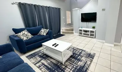 a living room with a blue couch and a tv at Amazing 3 Bdrm At Encantada- 6 miles from Disney in Kissimmee