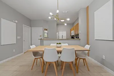 a dining room with a table and white chairs at Amazing 3Bdrms At Encantada -6 miles from Disney in Kissimmee