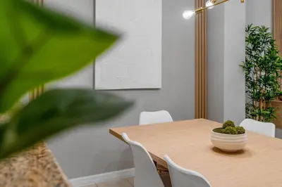 a dining room table with white chairs and a plant at Amazing 3Bdrms At Encantada -6 miles from Disney in Kissimmee
