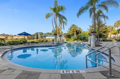 a swimming pool at a resort with palm trees at Cozy 3Bdrms At Encantada- 6 miles from Disney in Kissimmee