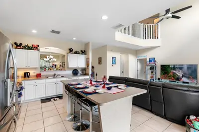 a kitchen with white cabinets and a black counter top at Family Friendly Emerald Island Resort Vacation Home with Private Pool and Spa Near Disney in Kissimmee