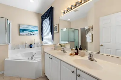 a bathroom with two sinks and a bath tub and a tubermott at Family Friendly Emerald Island Resort Vacation Home with Private Pool and Spa Near Disney in Kissimmee
