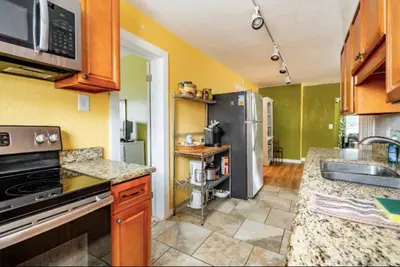 a kitchen with a sink and a refrigerator at 3-Bed Bungalow walk to Historic Downtown Sanford in Sanford
