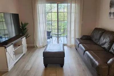 a living room with a leather couch and a table at Apartment Kissimmee - Orlando in Kissimmee