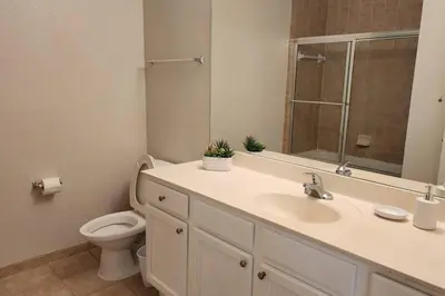 a bathroom with a sink and a toilet and a mirror at Apartment Kissimmee - Orlando in Kissimmee