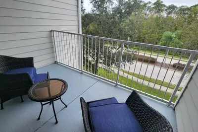 a porch with chairs and a table and a balcony at Apartment Kissimmee - Orlando in Kissimmee