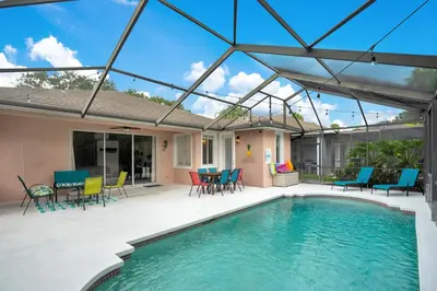 a patio with a pool and chairs and a table at Yelleville on Sunset! 4 Miles to Disney in Kissimmee