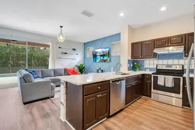 a kitchen with brown cabinets and a couch in a room at Yelleville on Sunset! 4 Miles to Disney in Kissimmee