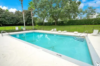 a large swimming pool with chairs and a fence at Yelleville on Sunset! 4 Miles to Disney in Kissimmee