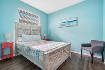a bedroom with blue walls and a bed and a chair at Yelleville on Sunset! 4 Miles to Disney in Kissimmee
