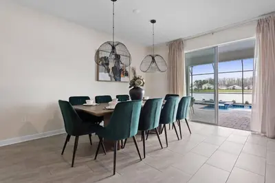 a dining room with a table and green chairs at 7 BR Large Pool Game Room @ Storey Lake SL2861 in Kissimmee