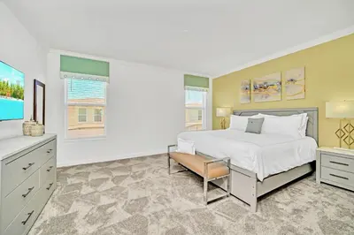 a bedroom with a large bed and a chair in it at Upstay 6BR Resort Home w Pool & Basketball Court in Kissimmee