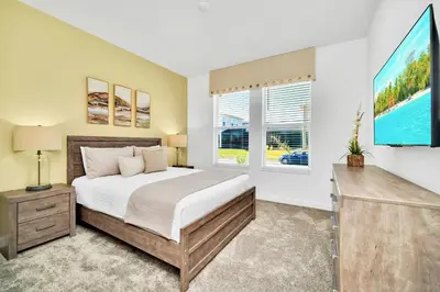 a bedroom with a large bed and a window at Upstay 6BR Resort Home w Pool & Basketball Court in Kissimmee