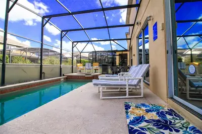 a swimming pool with two lounge chairs next to a building at Emerald Island Escape- Pool and spa in Kissimmee