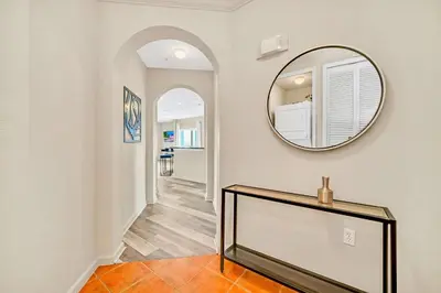 a hallway with a mirror on the wall and a table at Condo w Pool, Games Room - Pet Friendly in Orlando