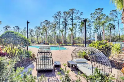 a patio with two chairs and a pool at Condo w Pool, Games Room - Pet Friendly in Orlando