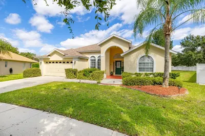 a house with a palm tree in a yard at #196-Fantastic 6 bed villa with own private pool and spa with no rear neighbors in Orlando