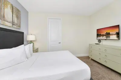 a white bedroom with a white bed and a dresser at Vibrant Home Near Disney With Private Pool, Game Room And Waterpark & Resort Access At Encore Resorts Reunion - 7572Mr in Kissimmee