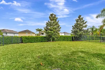 a yard with a fence and trees and houses at Vibrant Home Near Disney With Private Pool, Game Room And Waterpark & Resort Access At Encore Resorts Reunion - 7572Mr in Kissimmee