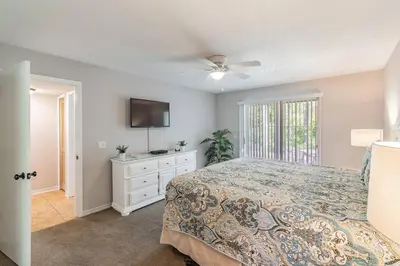 a bedroom with a bed and a flat screen tv at LOVE AT FIRST SIGHT! NEW Disney Home, Sleeps 6, Pool, Patio, NO Steps, LOW Rates! in Kissimmee