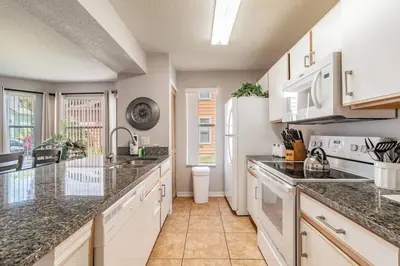 a kitchen with granite counter tops and white appliances at LOVE AT FIRST SIGHT! NEW Disney Home, Sleeps 6, Pool, Patio, NO Steps, LOW Rates! in Kissimmee