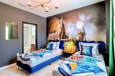 a bedroom with two beds and a painting on the wall at 8BR Resort Home with Games Room and BBQ in Kissimmee