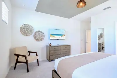 a bedroom with a bed and a chair and a dresser at 8BR Resort Home with Games Room and BBQ in Kissimmee