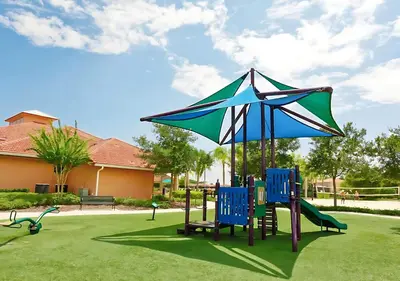 a playground with blue chairs and an umbrella at 8BR Resort Home with Games Room and BBQ in Kissimmee