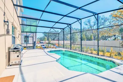 a swimming pool in a building with a glass ceiling at 8BR Resort Home with Games Room and BBQ in Kissimmee