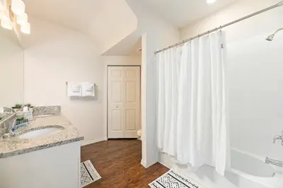 a white bathroom with a shower and a sink at Lovely and Cozy Townhome Near Disney Parks in Kissimmee