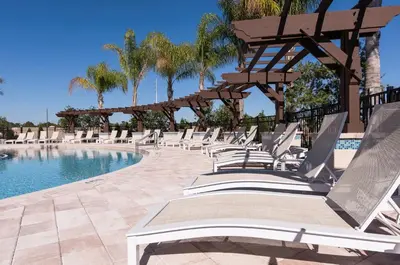 a row of lounge chairs next to a swimming pool at Lovely and Cozy Townhome Near Disney Parks in Kissimmee