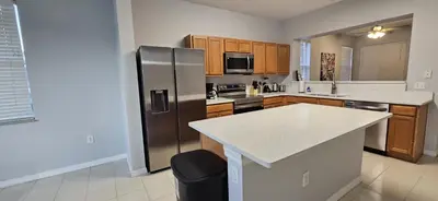 a large kitchen with a stainless steel refrigerator at Shvpc3 - Paradise Cay #3 - 3 Bed 25 Baths Townhome in Kissimmee