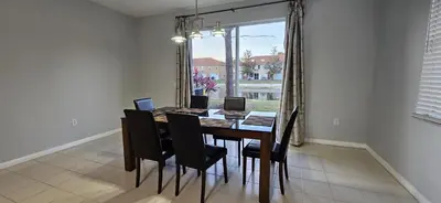 a dining room with a table and chairs and a window at Shvpc3 - Paradise Cay #3 - 3 Bed 25 Baths Townhome in Kissimmee
