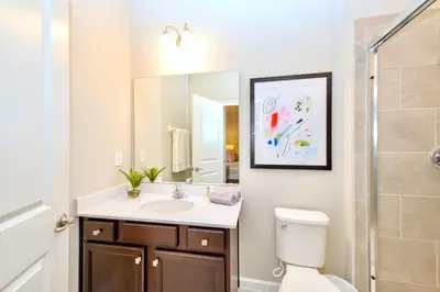 a bathroom with a sink and a toilet and a mirror at 15BR Mansion Home with Pool & Hot Tub-near Disney in Kissimmee