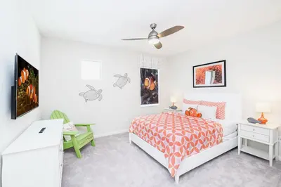 a white bedroom with a bed and a ceiling fan at 15BR Mansion Home with Pool & Hot Tub-near Disney in Kissimmee