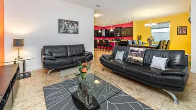 a living room with a black leather couch and a table at Paradise Palms Resort - 6 Bed 5 Baths Villa in Kissimmee