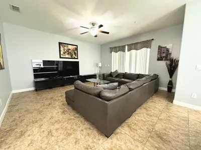 a living room with a couch and a flat screen tv at Paradise Palms Resort - 6 Bed 5 Baths Villa in Kissimmee