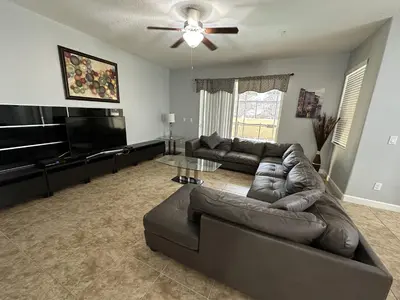 a living room with a couch and a flat screen tv at Paradise Palms Resort - 6 Bed 5 Baths Villa in Kissimmee