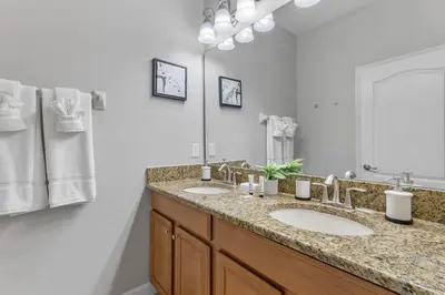 a bathroom with two sinks and a large mirror at New listing 5 mi from Disney,Free Arcades, HeatedPool & Water park in Kissimmee