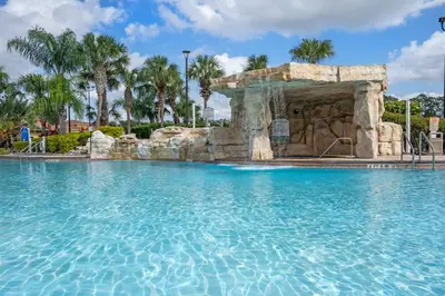 a swimming pool with a waterfall in a resort at New listing 5 mi from Disney,Free Arcades, HeatedPool & Water park in Kissimmee
